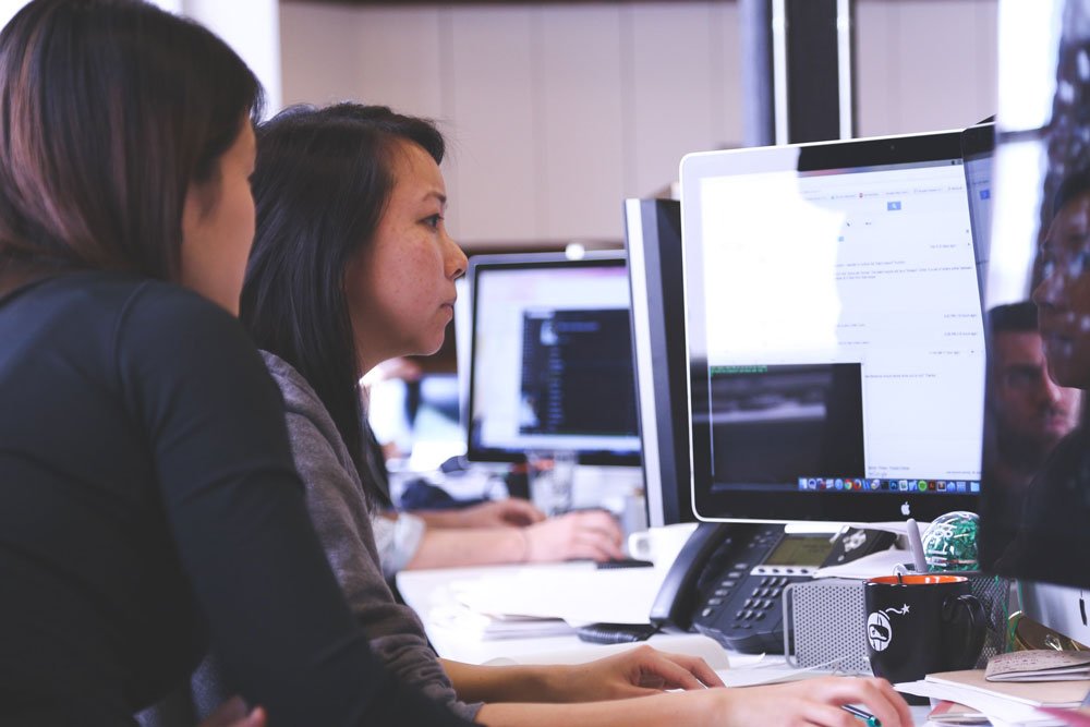 Women Analyzing Data on Desktop