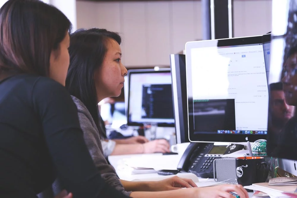 Women Analyzing Data on Desktop