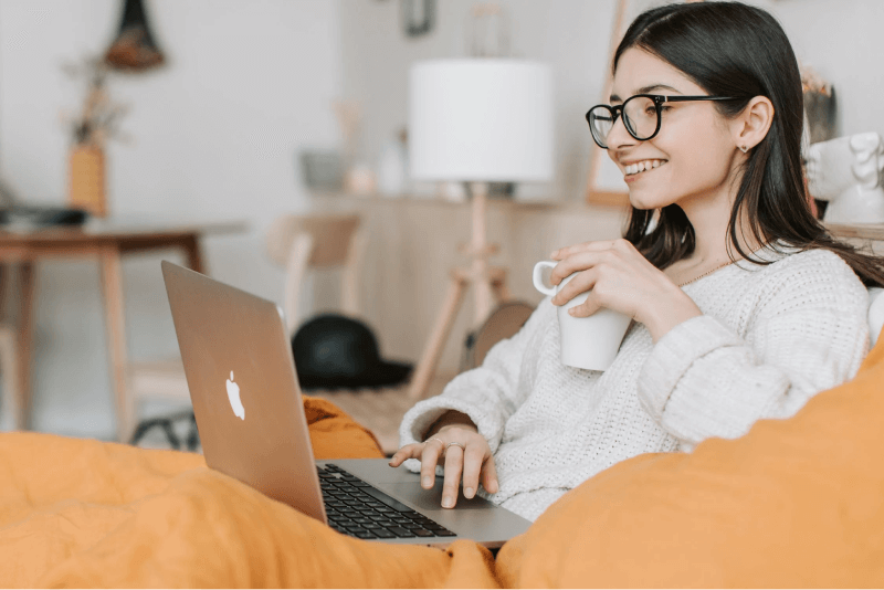 woman having coffee and using her laptop