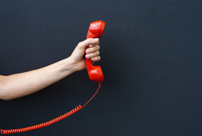 hand holding a red telephone