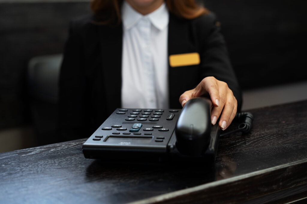 Receptionist using a business desk phone at the office